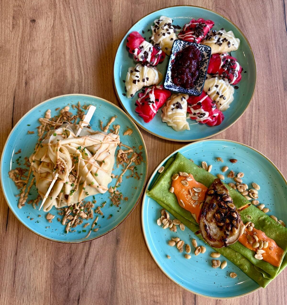 Hands preparing fresh homemade dumplings in bamboo steamers on a rustic kitchen table.
